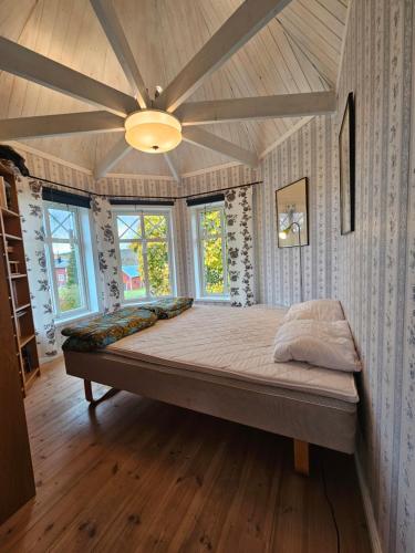 a large bed in a room with a ceiling fan at Romme stugby in Borlänge