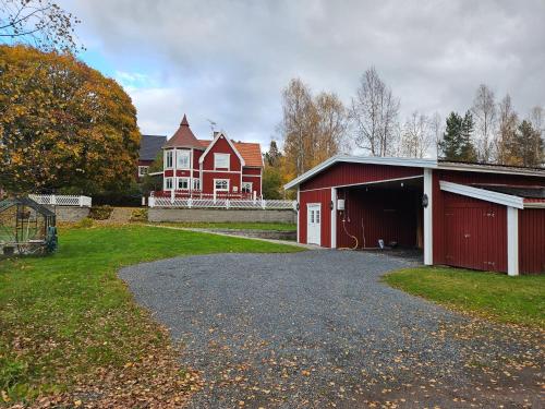 a red barn and a house with a garage at Romme stugby in Borlänge