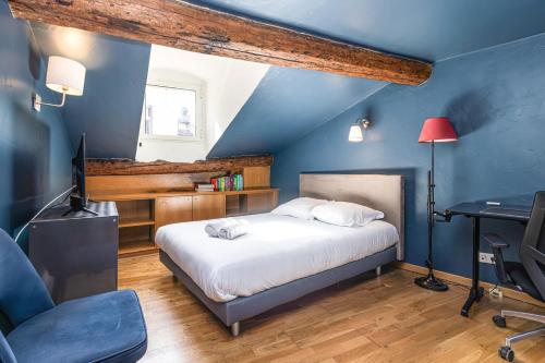 - une chambre avec des murs bleus et un lit avec un bureau dans l'établissement Triplex 150m2 coeur vieille ville, à Cannes