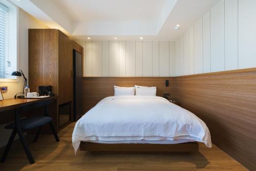 a bedroom with a bed and a desk and a bed sidx sidx sidx at Gran Hotel in Gunsan