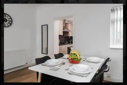 a kitchen with a table with plates and a bowl of fruit at Providence Luxury Apartment in Liverpool