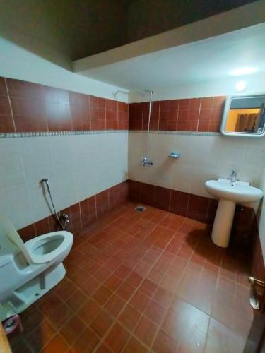 a bathroom with a toilet and a sink at HOTEL DAY IN Empouriem in Lahore