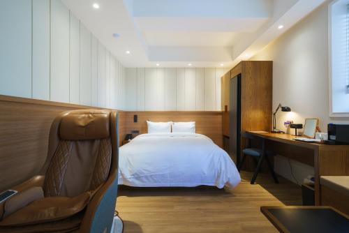 a hotel room with a bed and a desk and a chair at Gran Hotel in Gunsan