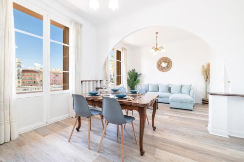 - un salon blanc avec une table et des chaises en bois dans l'établissement Large Central 2 Bdr & Garage, à Nice