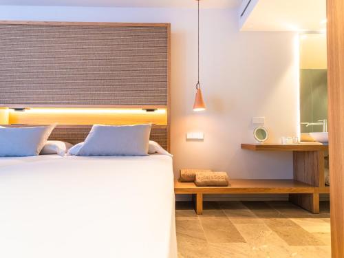 a bedroom with a bed and a bench and a window at Canyamel Park Hotel & Spa - 4* Sup - Adults only (+16) in Canyamel