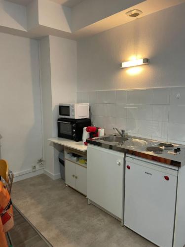 a kitchen with a sink and a microwave at Appartement - Centre historique in Fougères