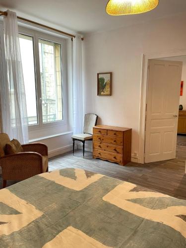 a living room with a bed and a chair and window at Appartement - Centre historique in Fougères