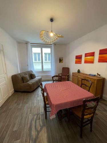 a living room with a table and a couch at Appartement - Centre historique in Fougères