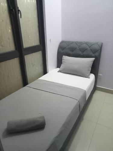a bed with a black headboard and a pillow on it at GR Homestay at Ayuman Suites Gombak in Kuala Lumpur