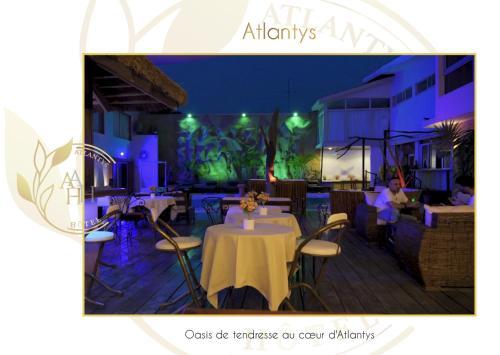 a restaurant with tables and chairs at night at Hotel l'ATLANTYS in Yopougon-Attié