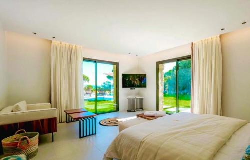 une chambre avec un lit et une grande fenêtre dans l'établissement Villa Régina, à Saint-Tropez