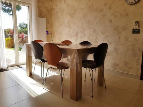 d'une table à manger entourée de 4 chaises. dans l'établissement Belle villa individuelle de plain pied 6 pers d'environ 90m2 - 6VPRIV19, à Saint Cyprien Plage