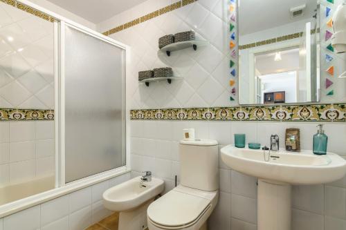 ein Badezimmer mit Toilette, Waschbecken und Spiegel in der Unterkunft Canela Park by H - Playa Isla Canela ICHP52P296 in Isla Canela