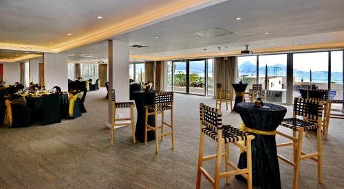 a banquet room with tables and chairs and windows at Lagoon Beach Hotel & Spa in Cape Town