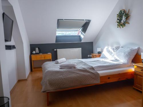 a bedroom with a bed with two towels on it at Vitrin Panzió in Nagymaros