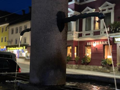 a water hose hooked up to a pole with a street at Alpin Apartments am Dorfbrunnen JUNIOR SUITE in Steinach am Brenner