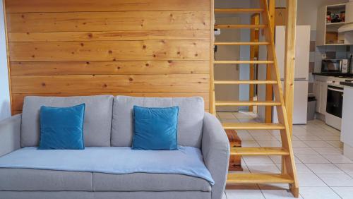 a couch with two blue pillows in a living room at Montricher Karellis, 5 min de St Jean de Maurienne in Montricher-Albanne