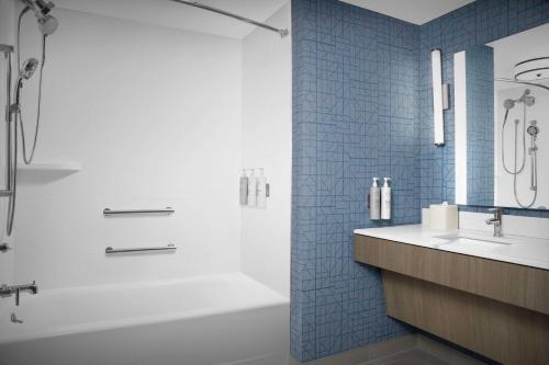 a bathroom with a tub and a sink and a shower at Homewood Suites by Hilton Jacksonville-Downtown/Southbank in Jacksonville