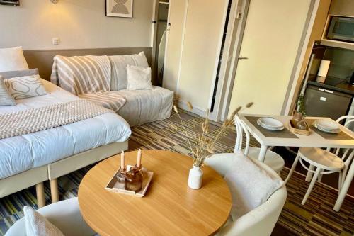 a living room with a table and a couch at Paris Porte de Versailles Cosy Lodge 2 Appart hôtel parking wifi 4 pers in Issy-les-Moulineaux