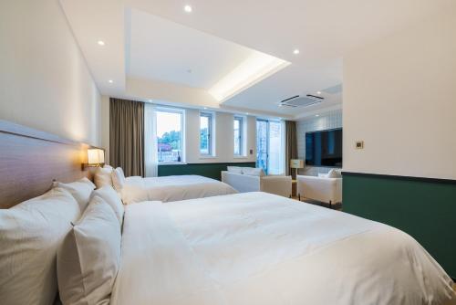 a hotel room with two beds and a bathroom at Gran Hotel in Gunsan