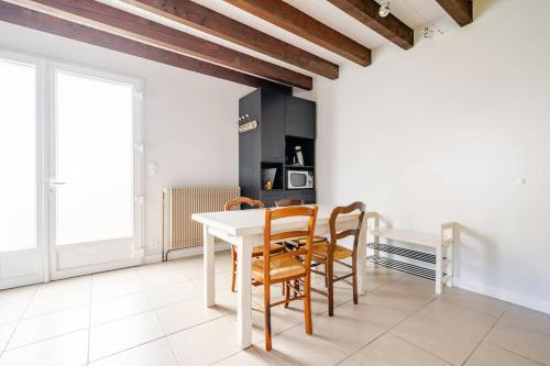 une salle à manger avec une table et des chaises blanches dans l'établissement Chez Lylou, à Perrier