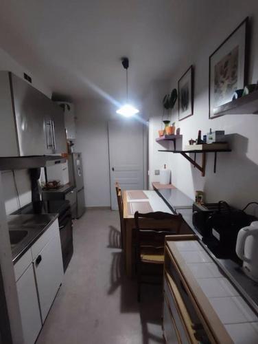une petite cuisine avec une table et des chaises. dans l'établissement Centralised Apartment in Paris, à Paris