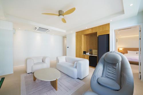 a living room with white furniture and a bed at Gran Hotel in Gunsan