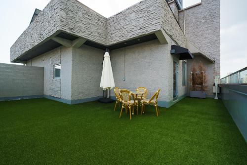 a patio with chairs and a table and a umbrella at Gran Hotel in Gunsan