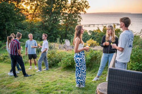 a group of people standing in the grass with drinks at Inselhotel Rügen in Göhren