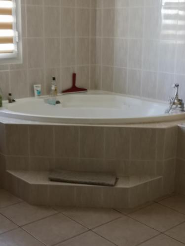 a bath tub in a bathroom with a sink at Le Chandelier in Saint-Joseph