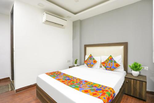 1 dormitorio con 1 cama blanca grande con sábanas coloridas en Via The Arrow, en Nueva Delhi