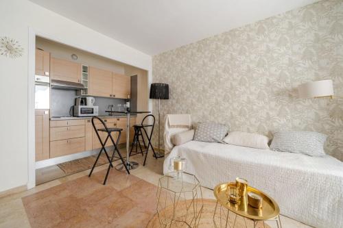 un salon avec un lit et une cuisine dans l'établissement Cannes Croisette Studio 3 pers Cosy CLIM WIFI PKG, à Cannes
