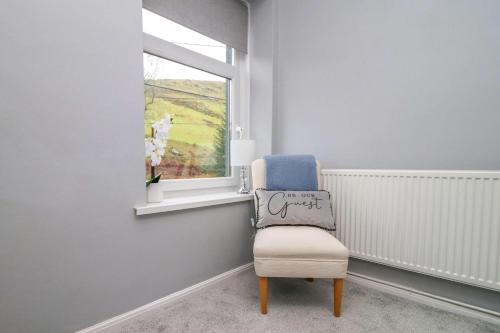 a chair in a room with a window at River View Large House In Afan Forest Bike Park By StayStaycations in Port Talbot