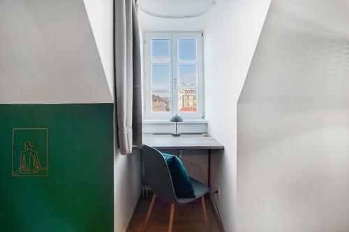 a room with a desk and a chair and a window at Emerald Design - Historic City Center with Free Parking & Panoramic View by HERO HOMES in Graz