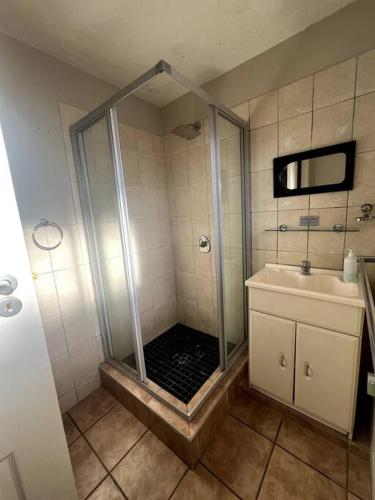 un baño con ducha y lavabo en 58 Chakas Rock Chalets, en Ballito
