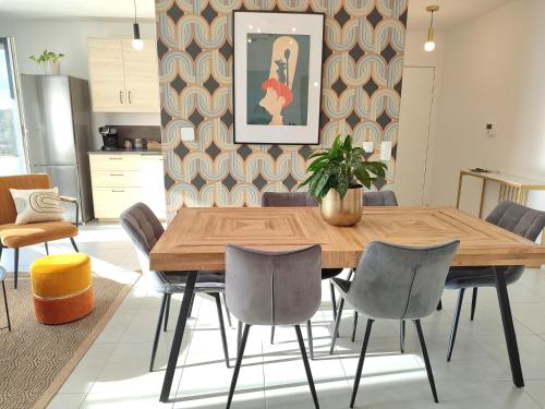 een eetkamer met een houten tafel en stoelen bij Disney Ratatouille Paris 5mn park & Val d'Europe in Chessy