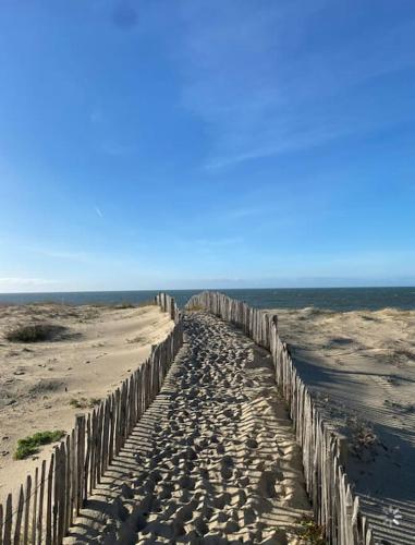 une clôture en bois sur la plage près de l'océan dans l'établissement Maison posée sur la plage, à La Turballe