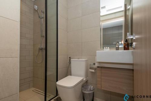 a bathroom with a toilet and a sink and a shower at Modern Contemporary Studio in Azizi Riviera in Dubai