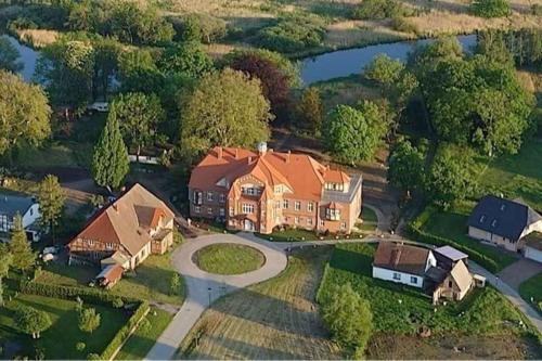 a large house with a driveway and a house at Schloss Pütnitz - Kanuspezial ab 4 Ü 06 Jan bis 29 April in Ribnitz-Damgarten