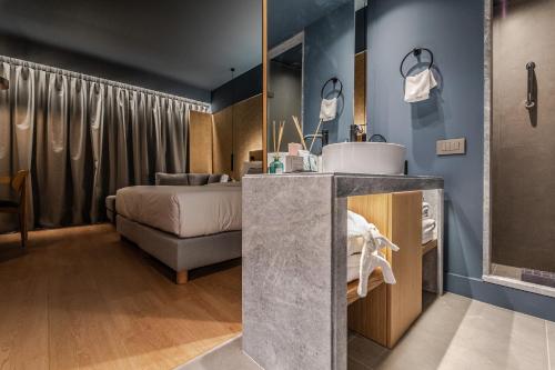 a bathroom with a sink and a bed in a room at Magnes Hotel in Volos