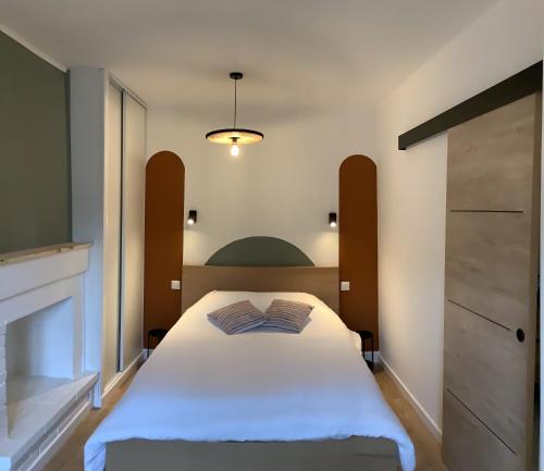 - une chambre avec un lit blanc et une cheminée dans l'établissement L'Echappée Polletaise Central Typique Wifi, à Dieppe