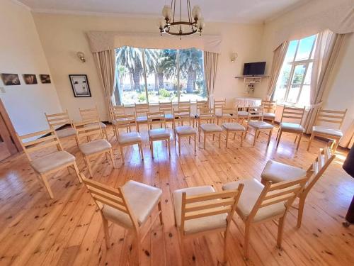 a room with a large room with chairs and a table at Hotel Prinzessin Rupprecht in Swakopmund
