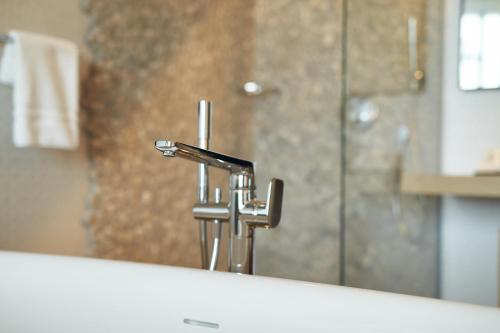a bathroom sink with a faucet and a mirror at Van Der Valk Luxembourg Arlon in Arlon