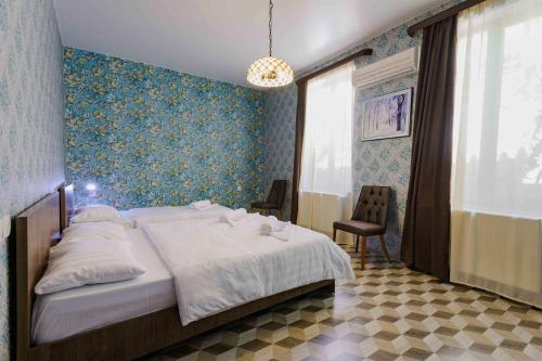 a bedroom with a large bed with a blue wall at Urban Villa Tbilisi City in Tbilisi City