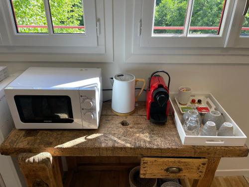 - un four micro-ondes installé sur une table en bois dans la cuisine dans l'établissement Le Petit Nid du Vieux Logis Ravissante Suite dans vallée troglodyte, à Saint-Épain