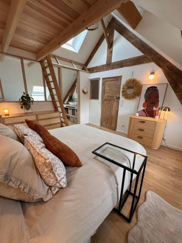 une chambre avec un grand lit dans un grenier dans l'établissement Duplex Cosy et Bohème avec parking proche Calais, à Coulogne