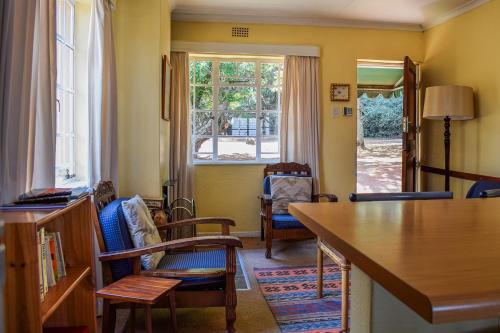 un salon avec une table et des chaises et une fenêtre dans l'établissement Dabchick Cottage, à Dullstroom
