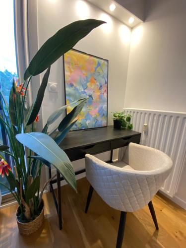 - un salon avec une télévision, une chaise et une plante dans l'établissement Le Repos Montchatois - Appartement moderne, à Lyon