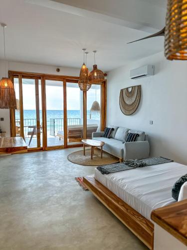 a bedroom with a bed and a view of the ocean at KUDOS Beach Apartments Jambiani in Jambiani