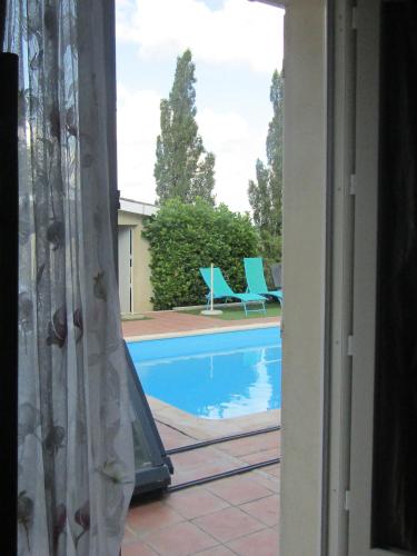 a view of a swimming pool from a window at Galinat in Culmont